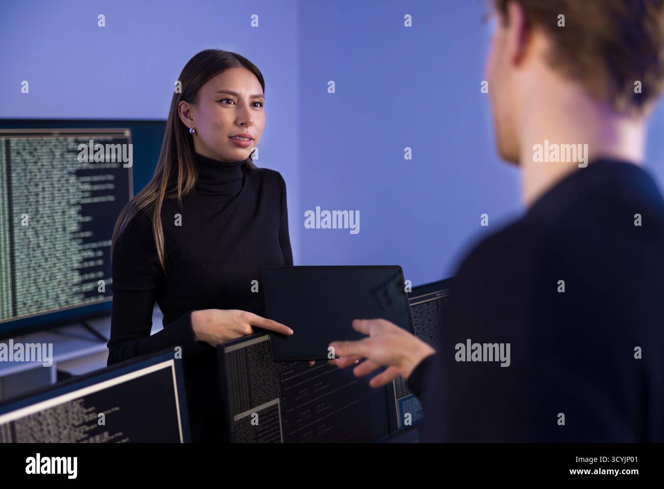 Two cybersecurity professionals collaborating in a security operations center Stock Photo