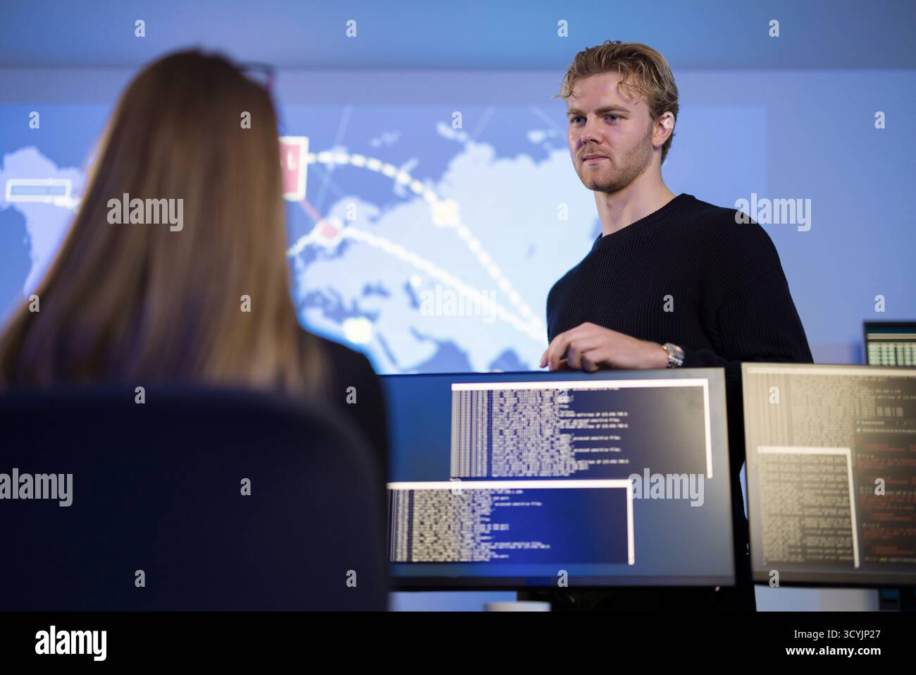 Team analyzing cyber threats using monitors in a security operations center Stock Photo