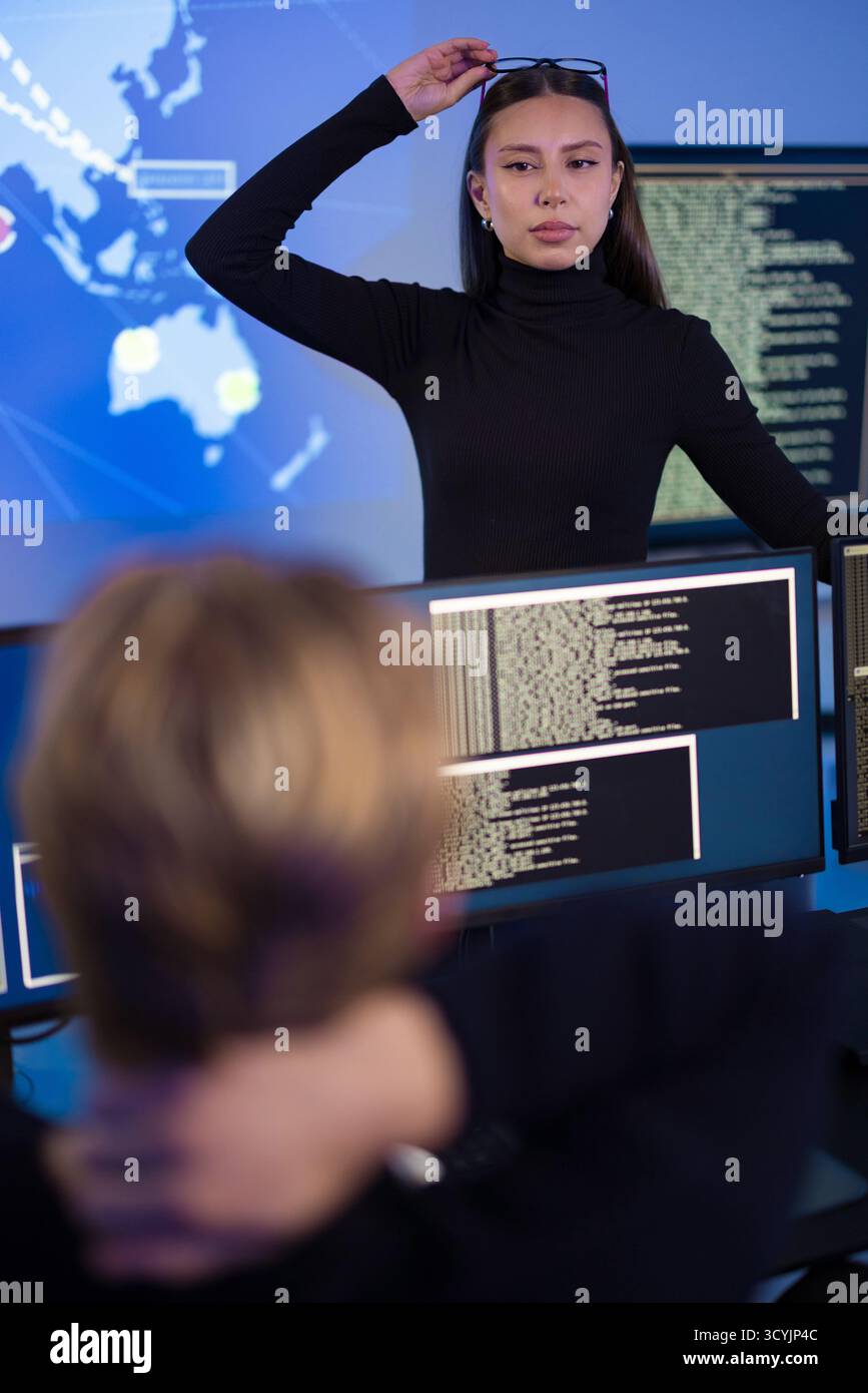 Cybersecurity professionals analyzing real-time threats in a high-tech operations center Stock Photo