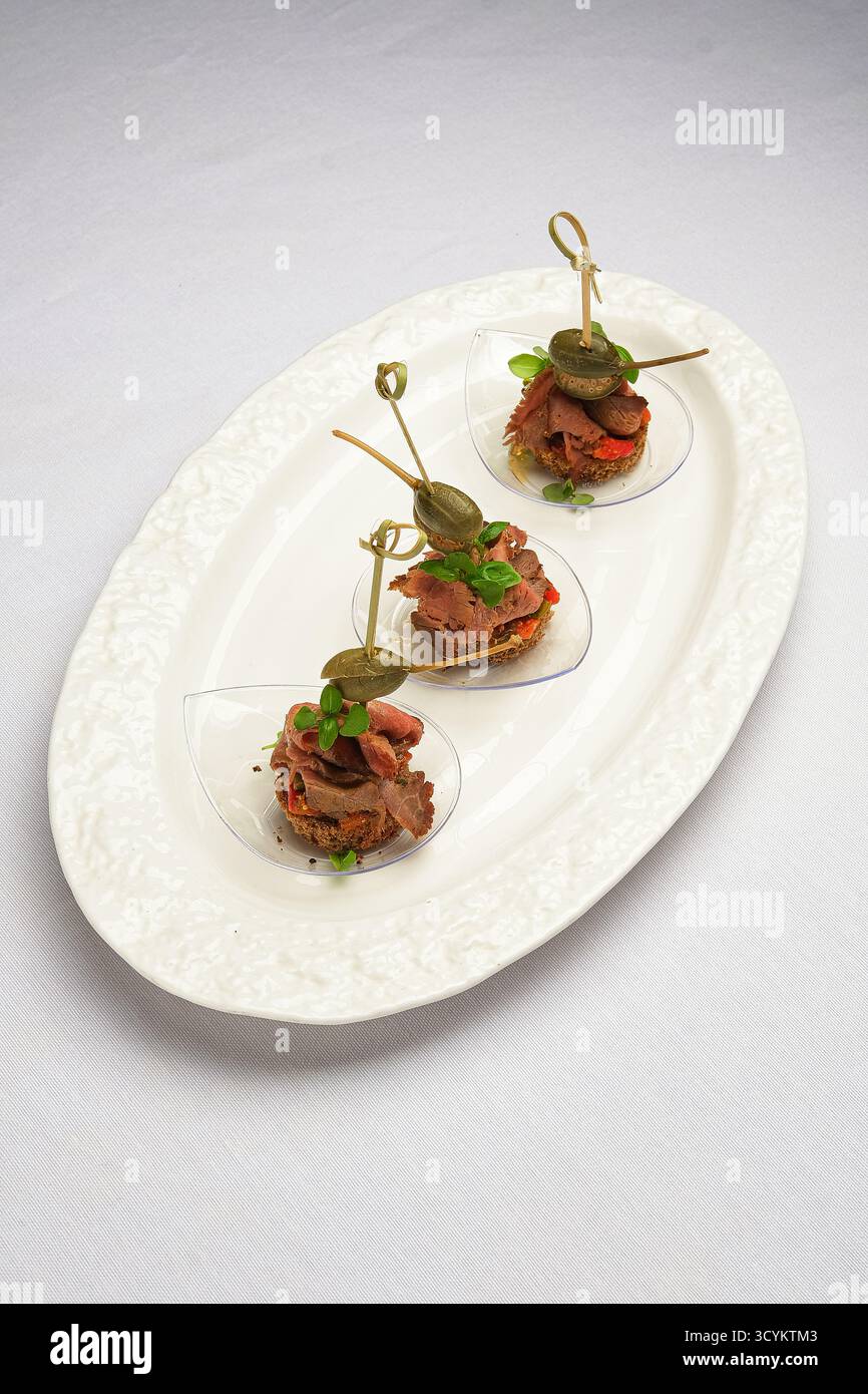 refined mini tartare bites on toast with microgreens and chipotle aioli for cocktail parties Stock Photo