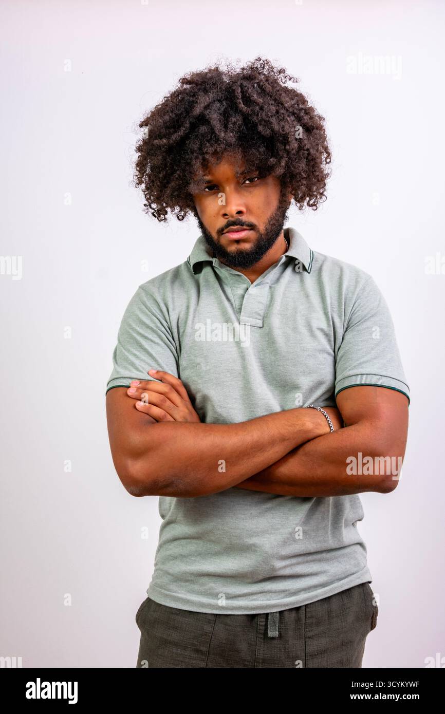 Young black man with curly hair standing confidently, expressing determination Stock Photo