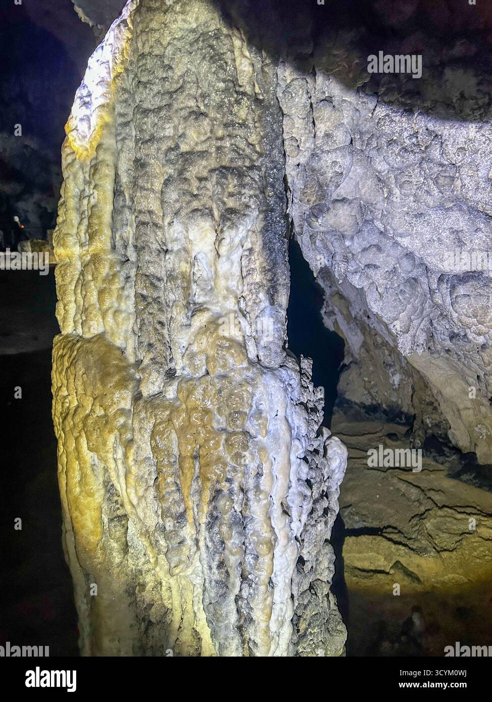 Limestone formations and a narrow passage inside the Ice Cave in Uvac Canyon, Serbia, illuminated by artificial light during exploration. - Smartphone Captured Stock Image