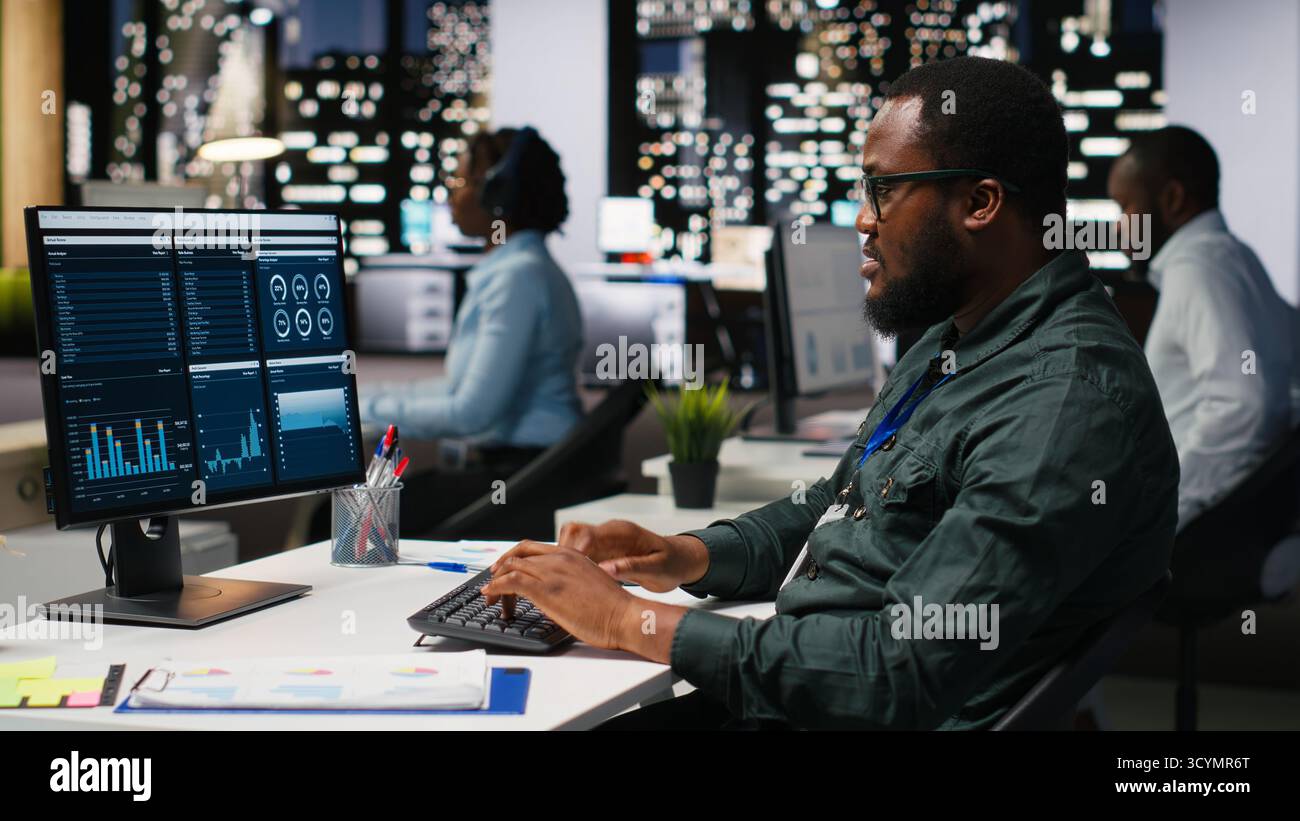 Monitor Success Office worker reviewing KPI metrics on monitor and analytics on desktop ...
