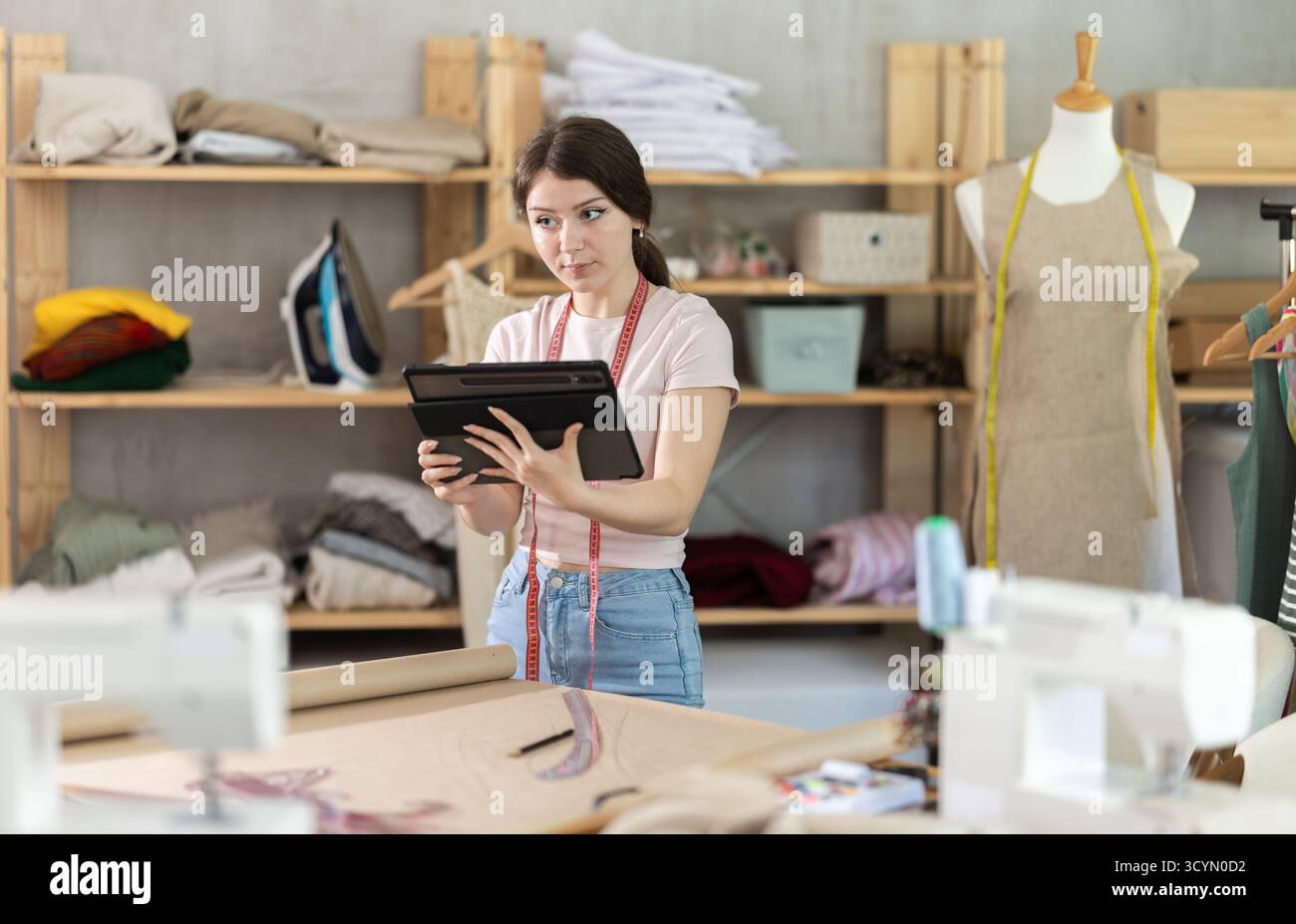 Woman dressmaker makes pattern using tablet Stock Photo