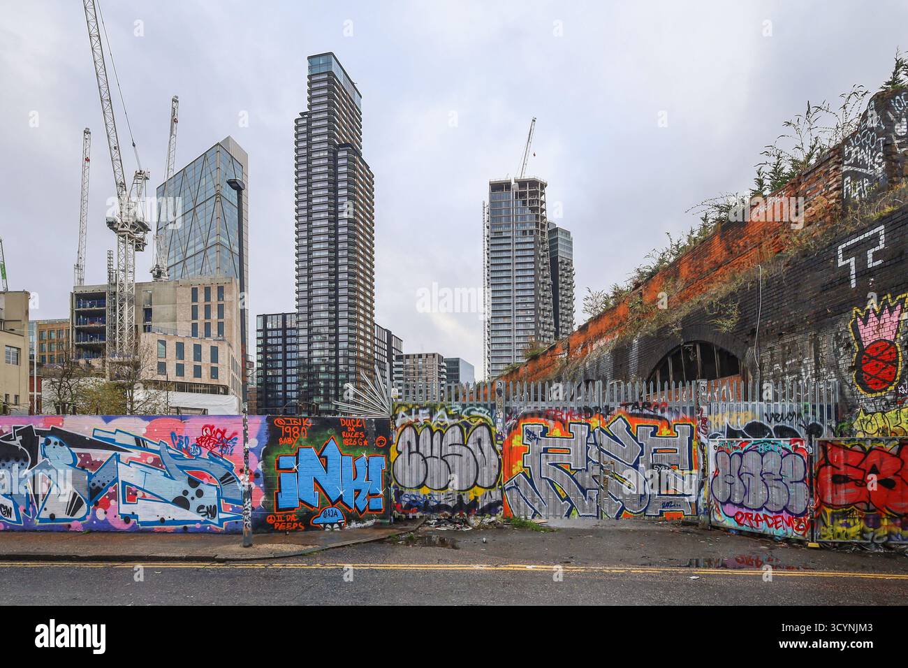 East London graffiti street art near brick lane aldgate juxtaposed with tall skyscrapers on the city skyline at Liverpool St Stock Photo