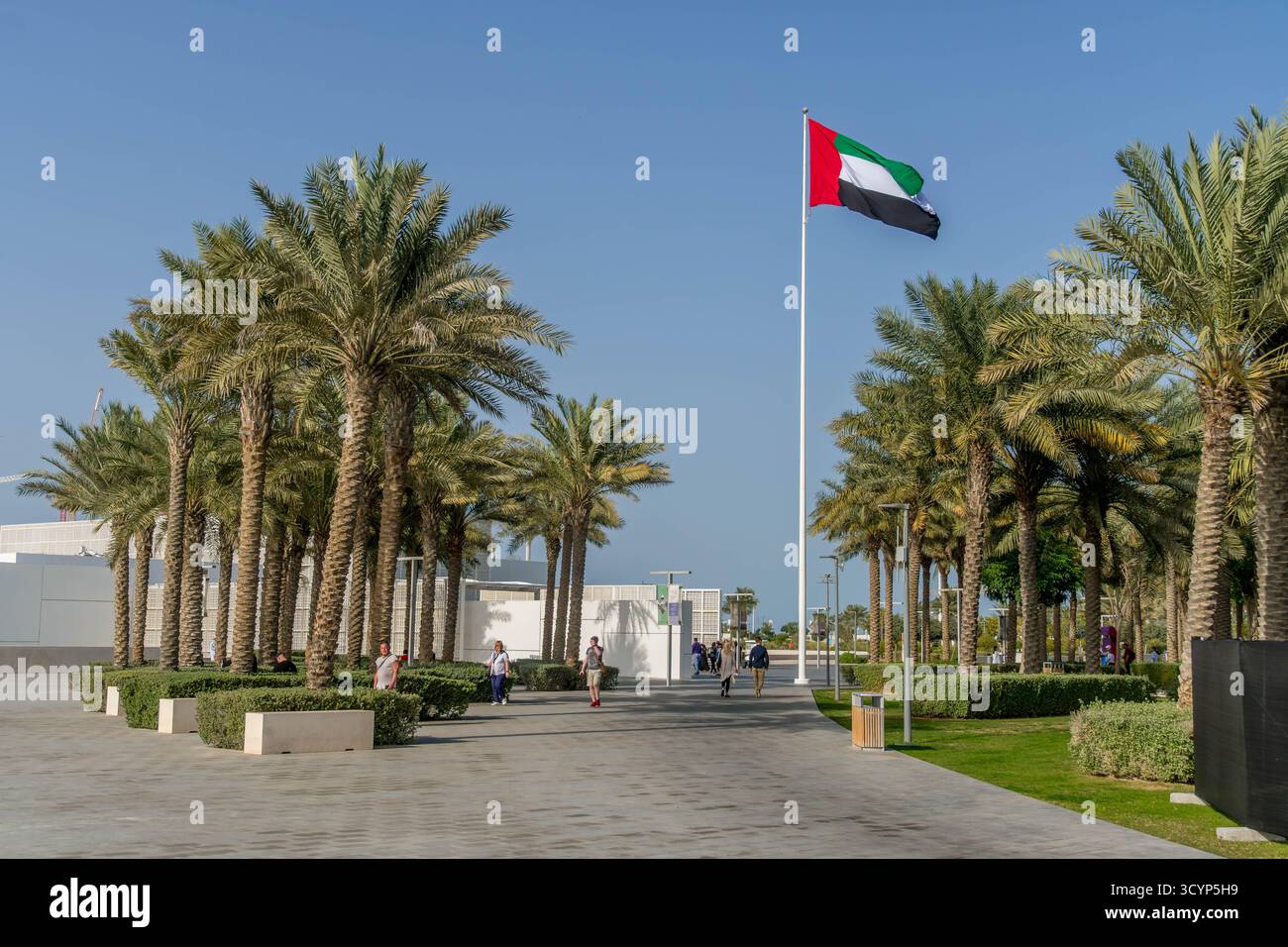 UAE flag in Abu Dhabi, UAE, with tourists. Stock Photo