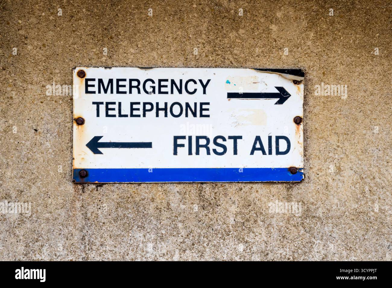 An old street sign pointing the way to an Emergency Telephone and First Aid in Hunstanton, Norfolk. Stock Photo