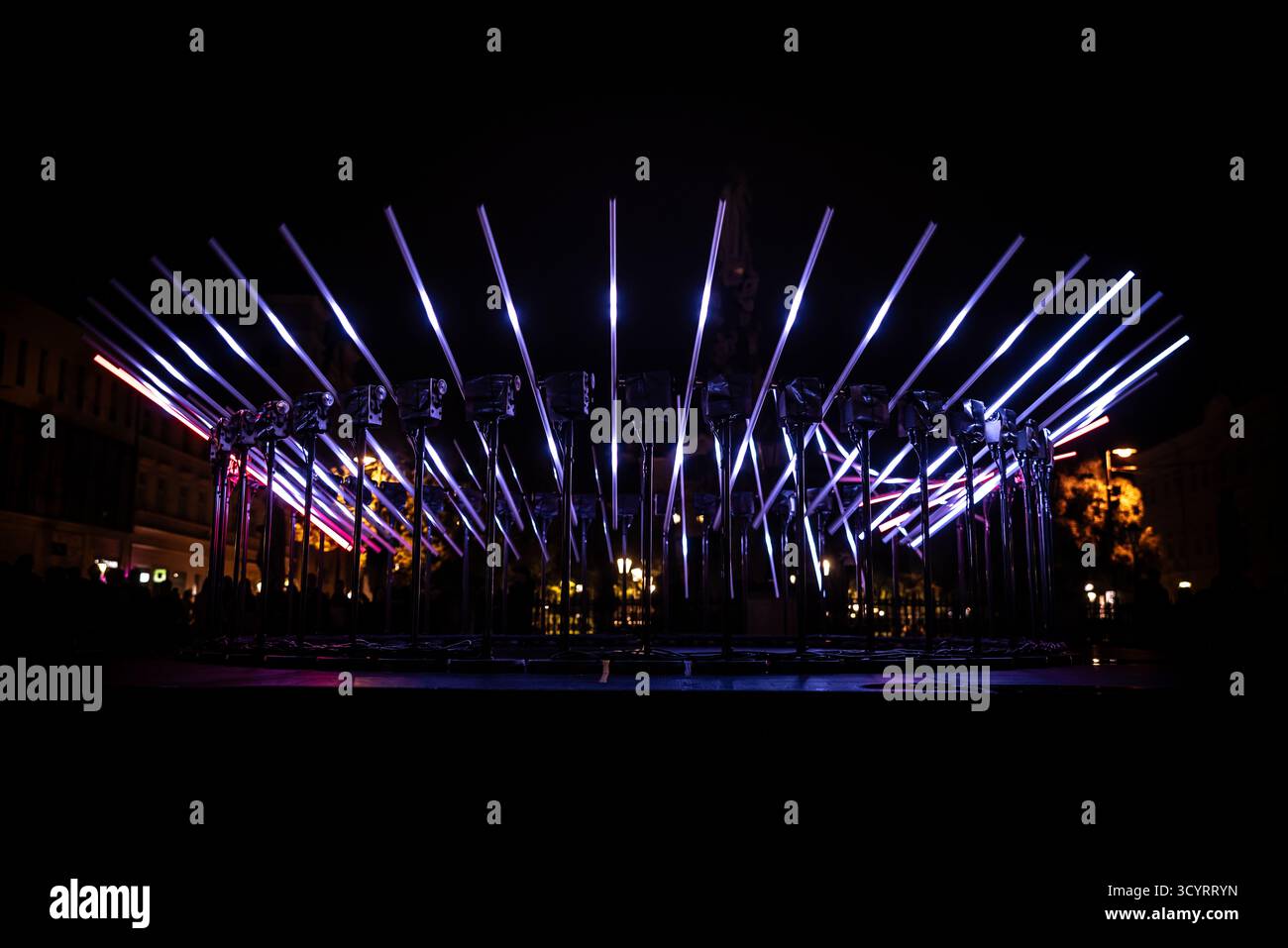 The fascinating night scene captures a modern light installation that dominates the space with a futuristic aesthetic and consists of a number of diag Stock Photo