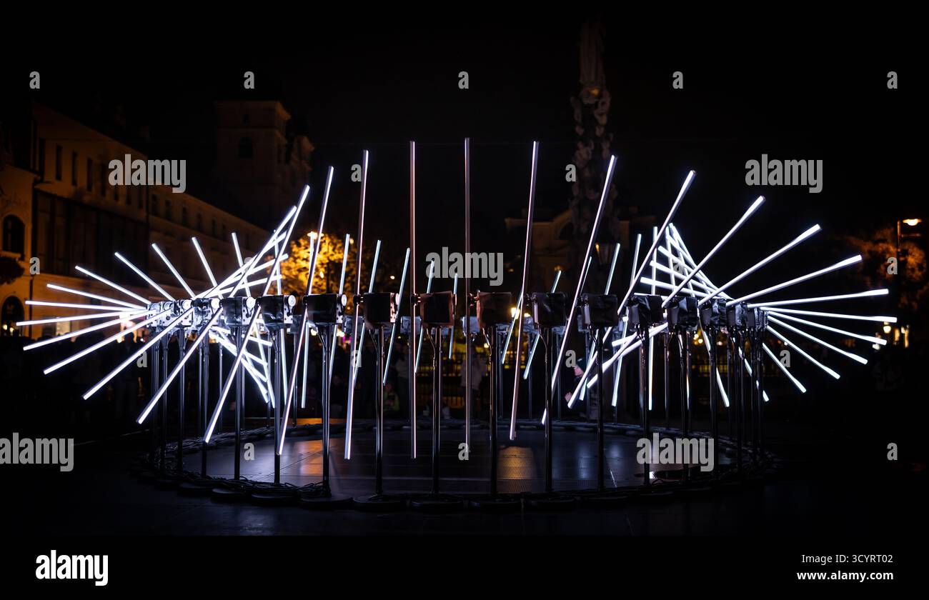 The fascinating night scene captures a modern light installation that dominates the space with a futuristic aesthetic and consists of a number of diag Stock Photo