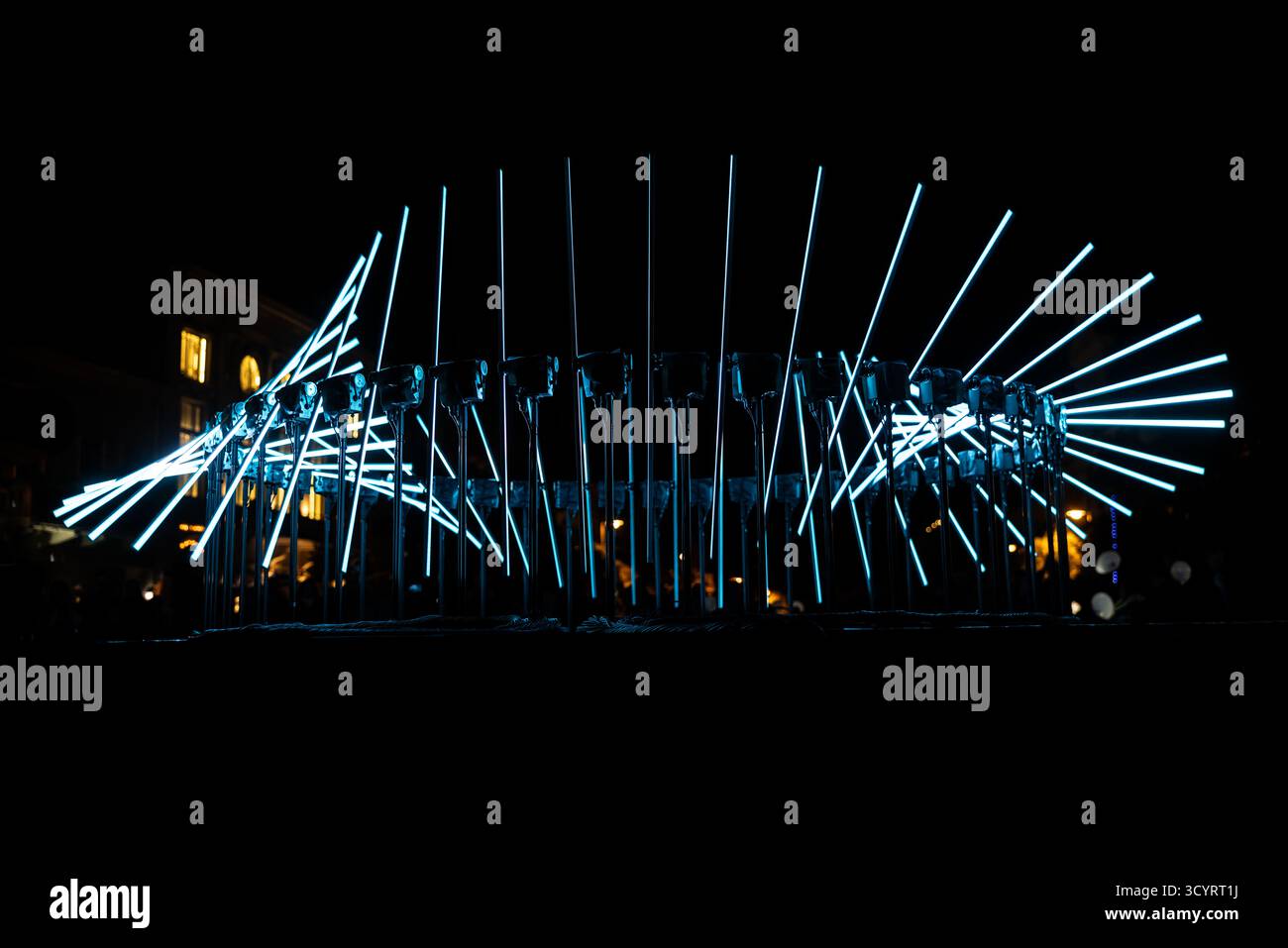 The fascinating night scene captures a modern light installation that dominates the space with a futuristic aesthetic and consists of a number of diag Stock Photo