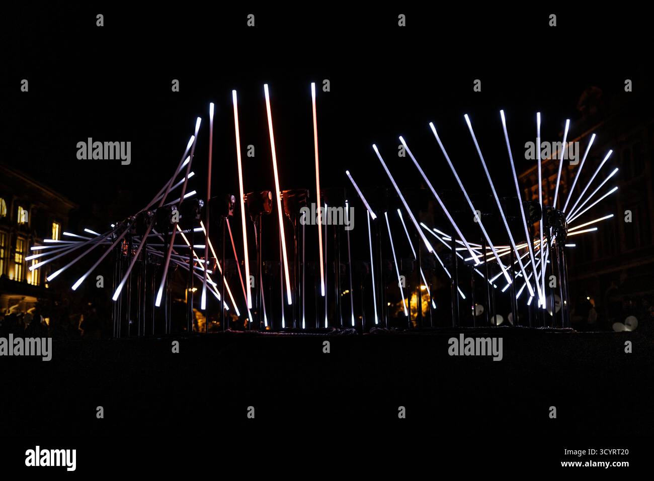 The fascinating night scene captures a modern light installation that dominates the space with a futuristic aesthetic and consists of a number of diag Stock Photo