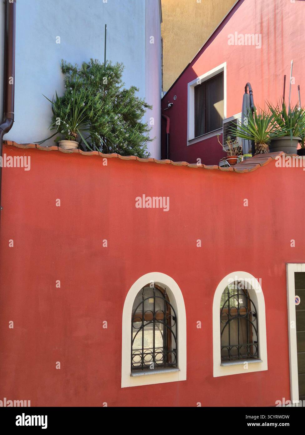 beautiful red houses with small windows and potted plants - Smartphone Captured Stock Image