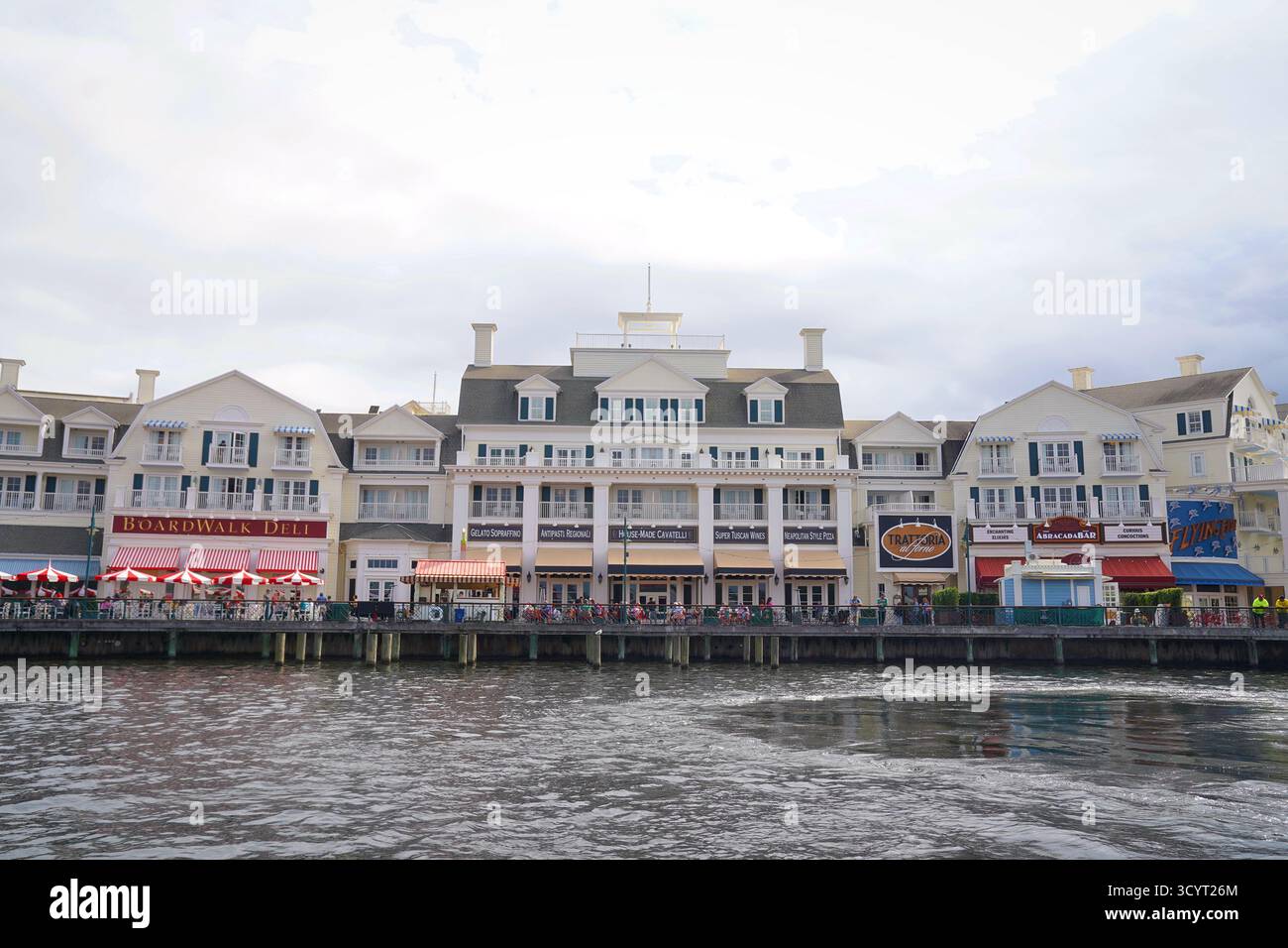 Panoramic view of Disney’s BoardWalk dining district with BoardWalk Deli, Trattoria al Forno, and other waterfront restaurants under cloudy skies Stock Photo