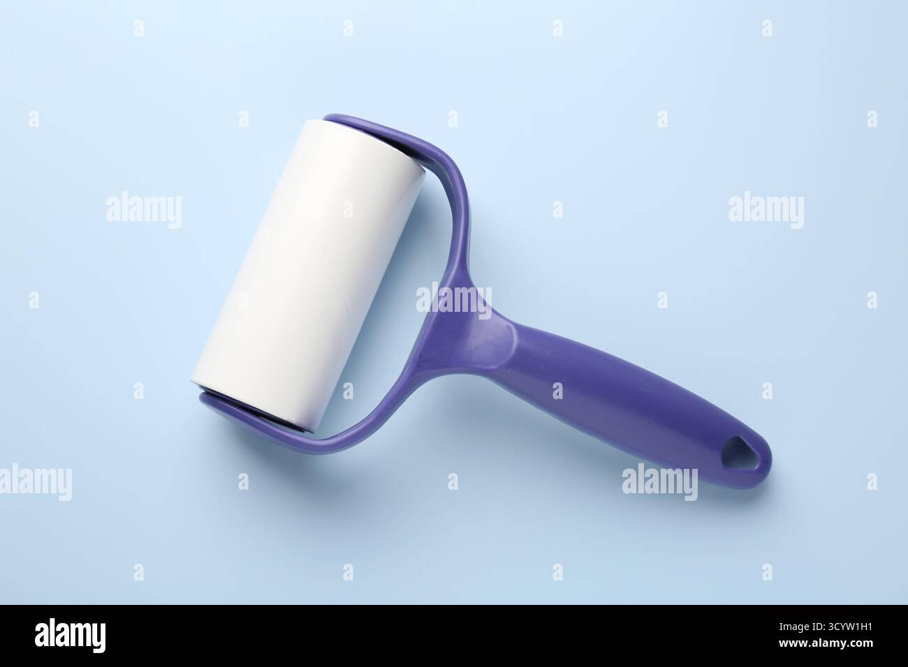 One lint roller on light blue background, top view Stock Photo