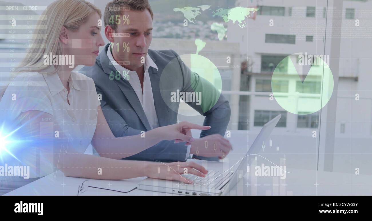 Collaborating two professionals analyzing figures at urban office, with laptop and digital overlays Stock Photo