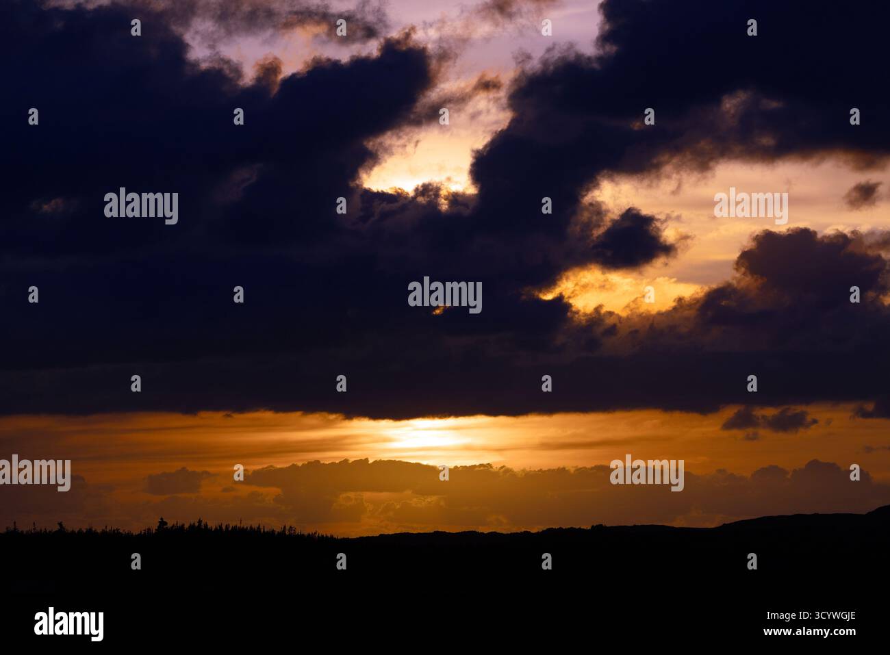 Dramatic Sunset with Dark Clouds Over Newfoundland Landscape Stock Photo