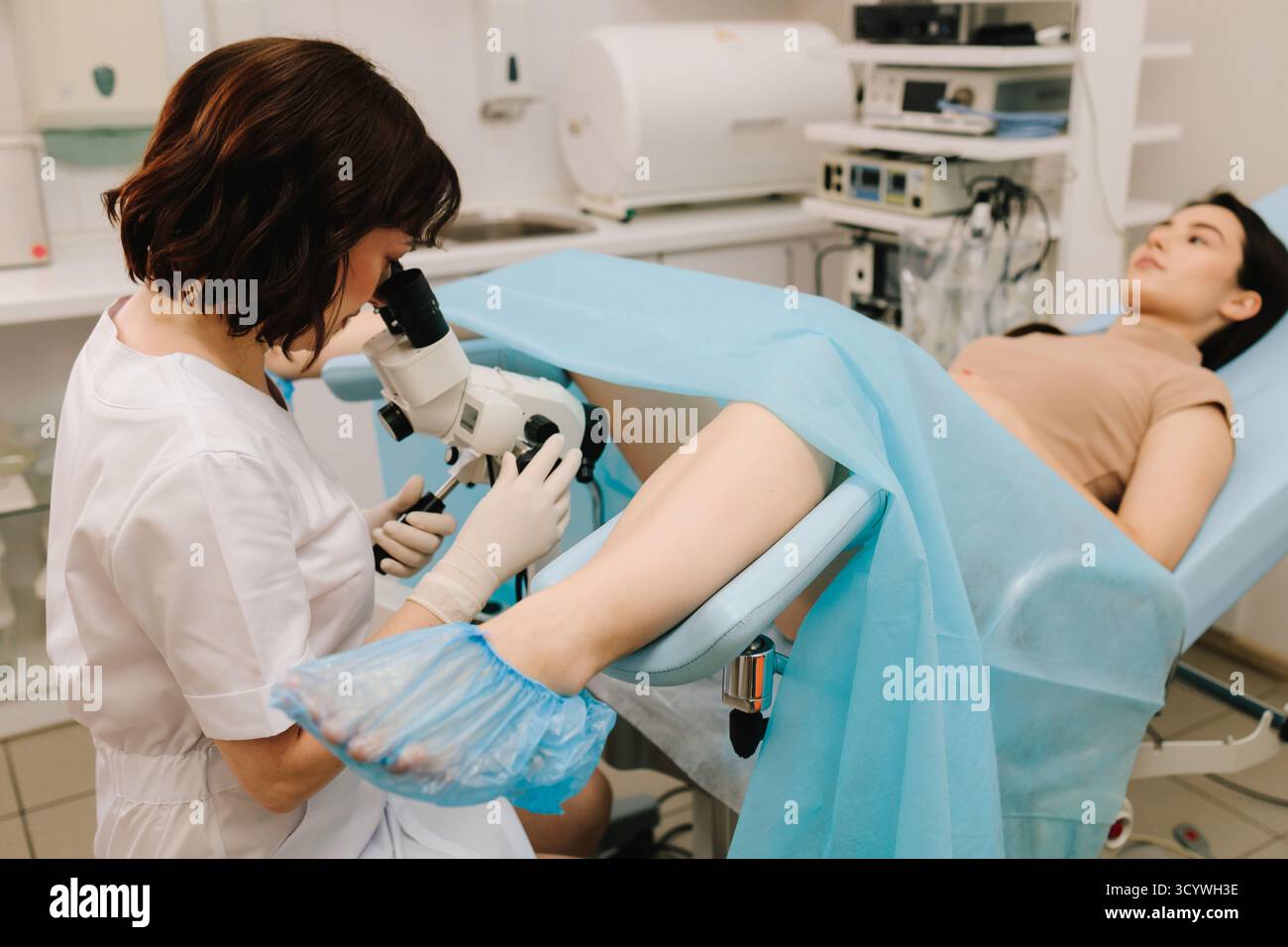 Gynecologist performs colposcopy with professional microscope. Patient ...