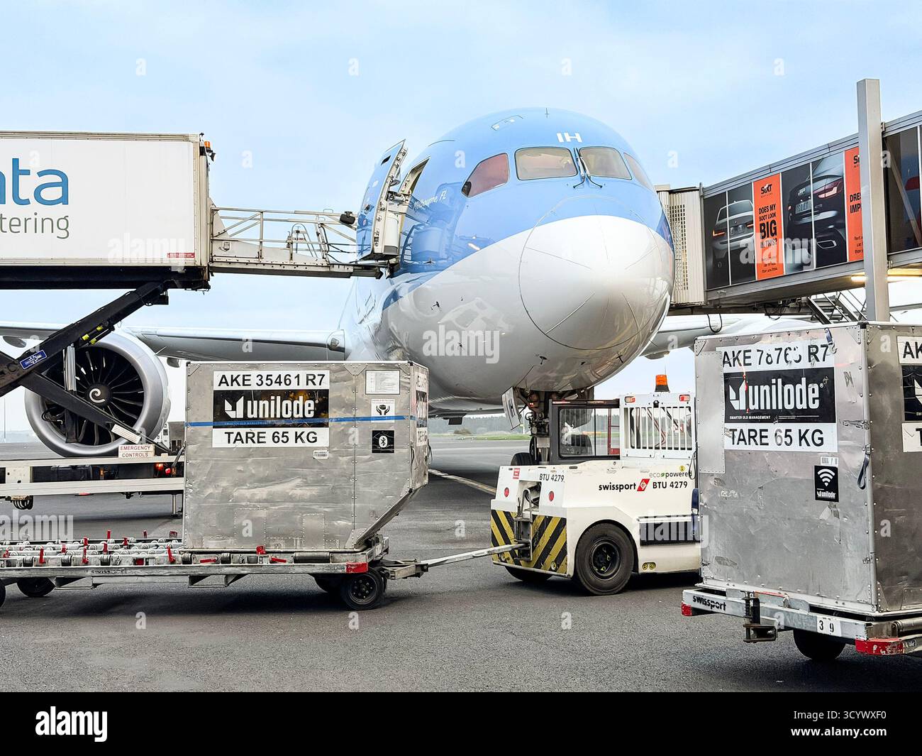 A commercial Tui airplane at the airport being loaded with cargo using specialized equipment and service vehicles. - Smartphone Captured Stock Image