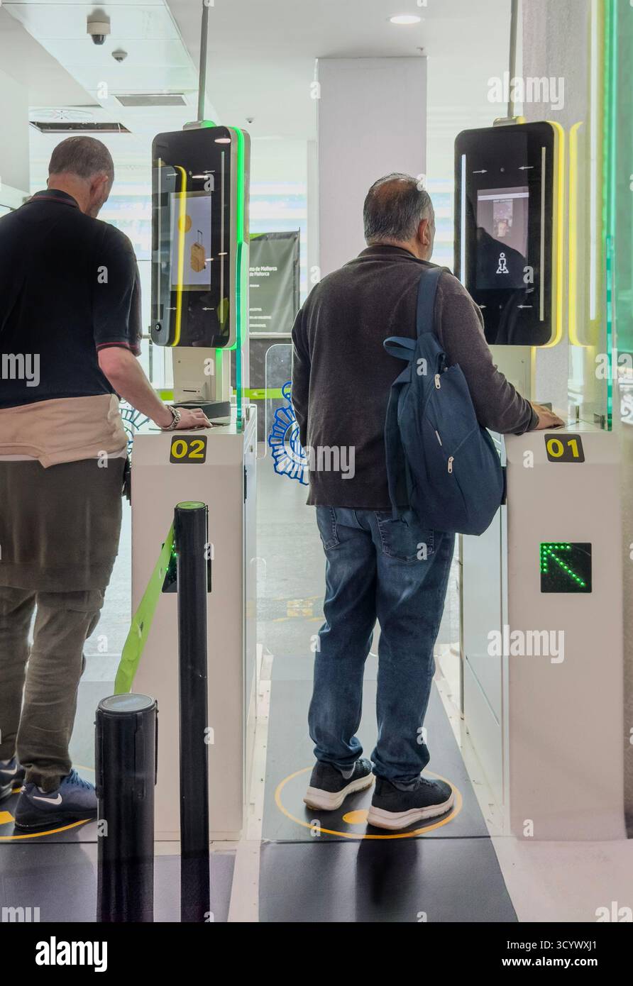 Two men stand at electronic self-check-in kiosks in newcastle international airport, using technology for entry. EES new system - Smartphone Captured Stock Image