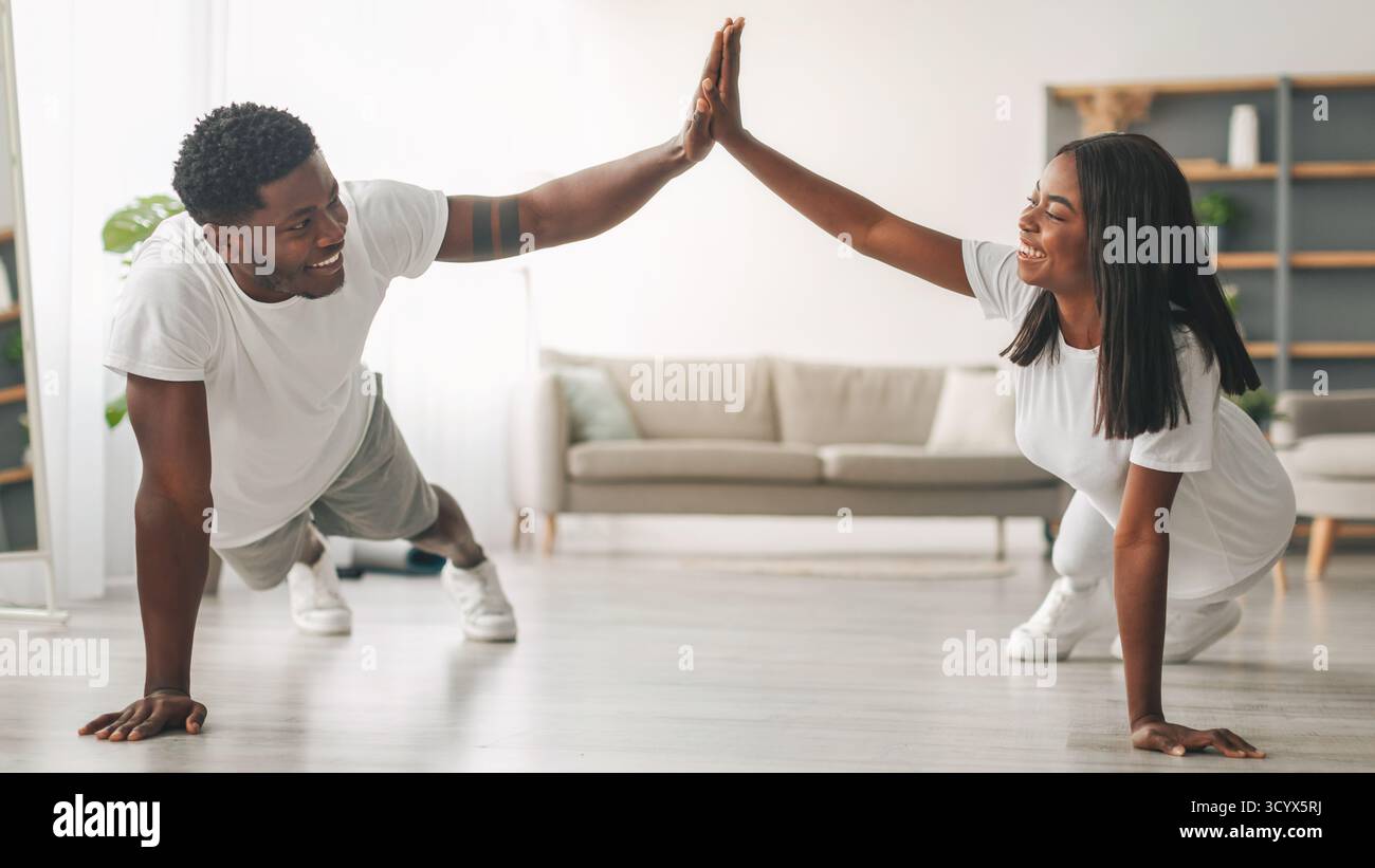 Young black couple planking and giving high five Stock Photo