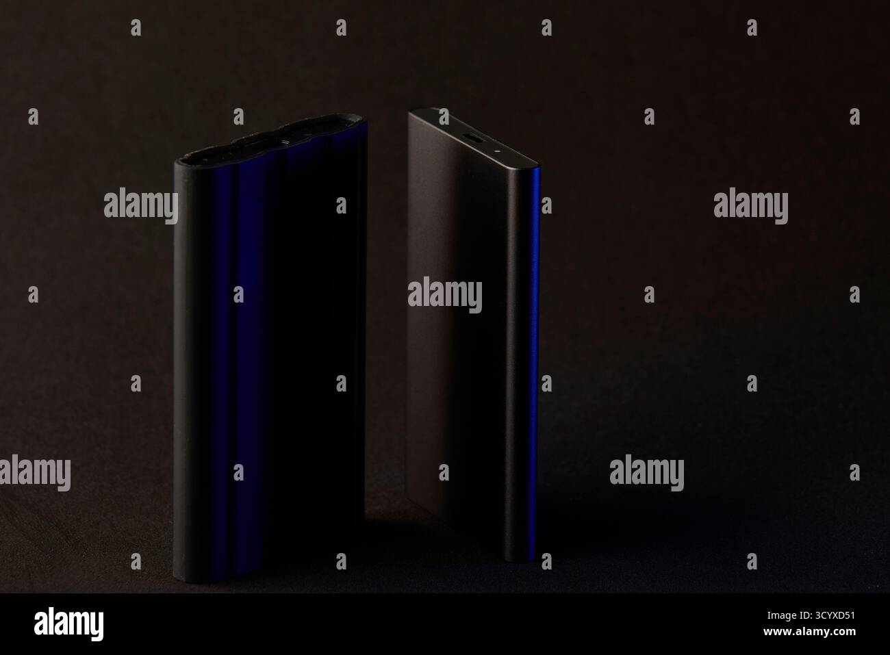 Two sleek SSD drives standing upright on black surface with soft light reflections. Clean technology concept highlighting data security, performance, Stock Photo