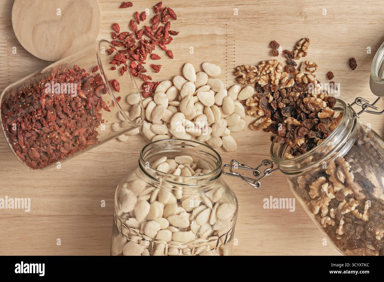 Composition with fried almonds with Honey, muscatel raisins, cracked walnuts, and goji berries on a slate board Stock Photo