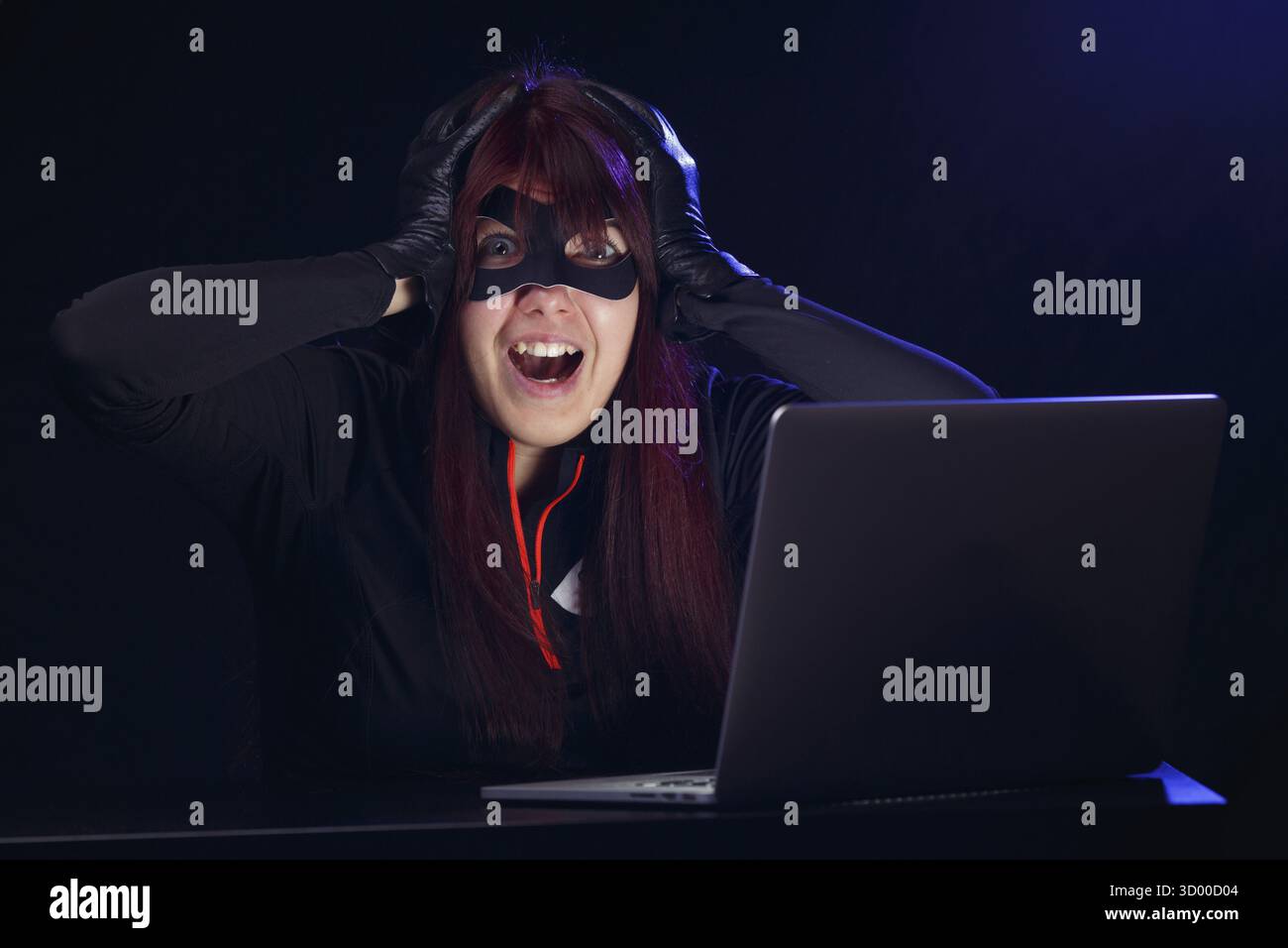 Brunette steals information from computer at night Stock Photo