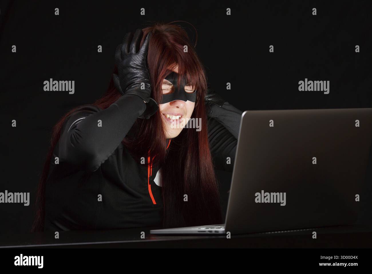 Happy hacker in black mask next to computer Stock Photo - Alamy