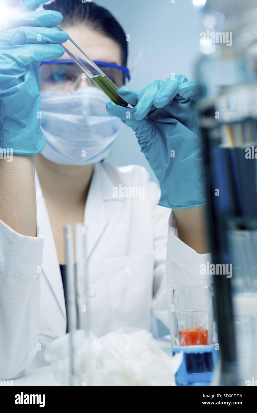Young scientist with test tubes in laboratory Stock Photo
