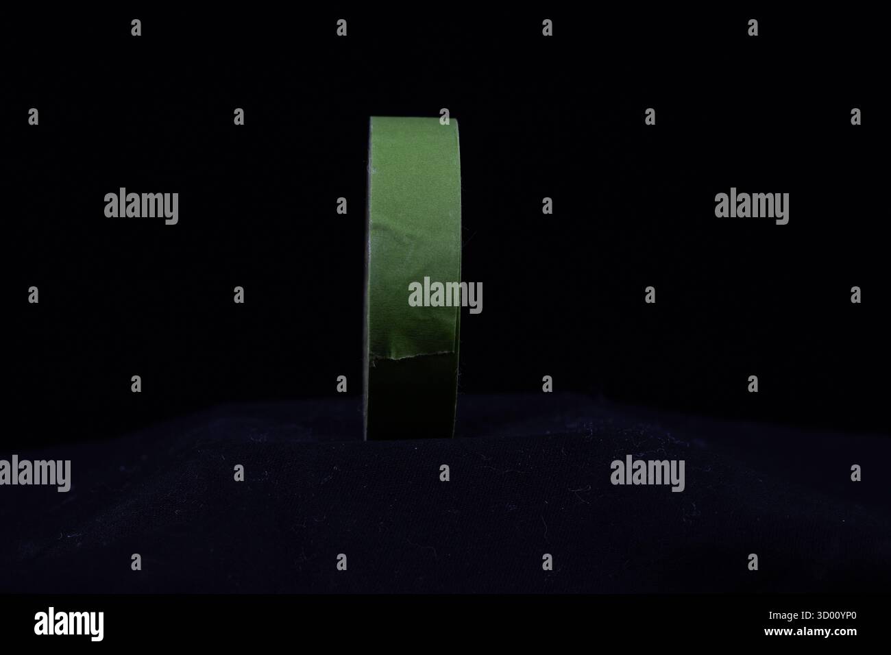 single green roll of decorators masking tape isolated on a black background Stock Photo