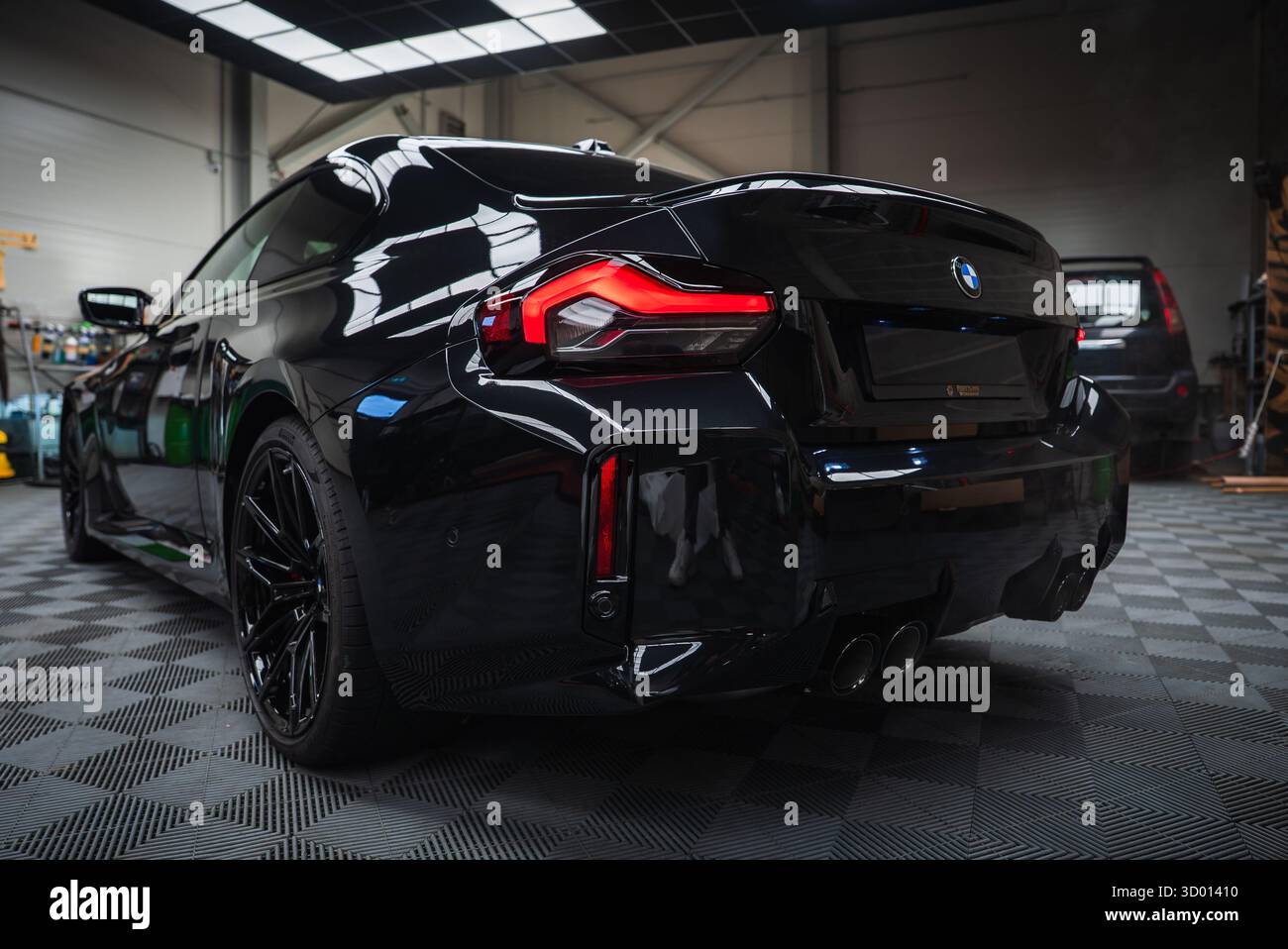 Low rear three quarter view of a 2025 BMW M2 in a workshop Stock Photo ...