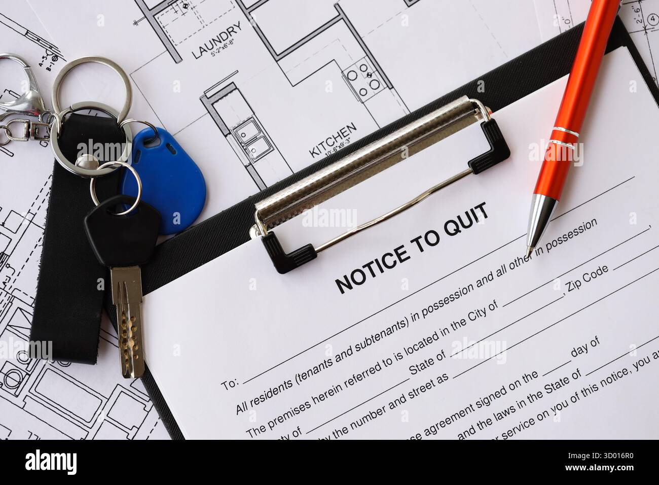 Pen and keys on Notice to quit form and planning blueprints of ...