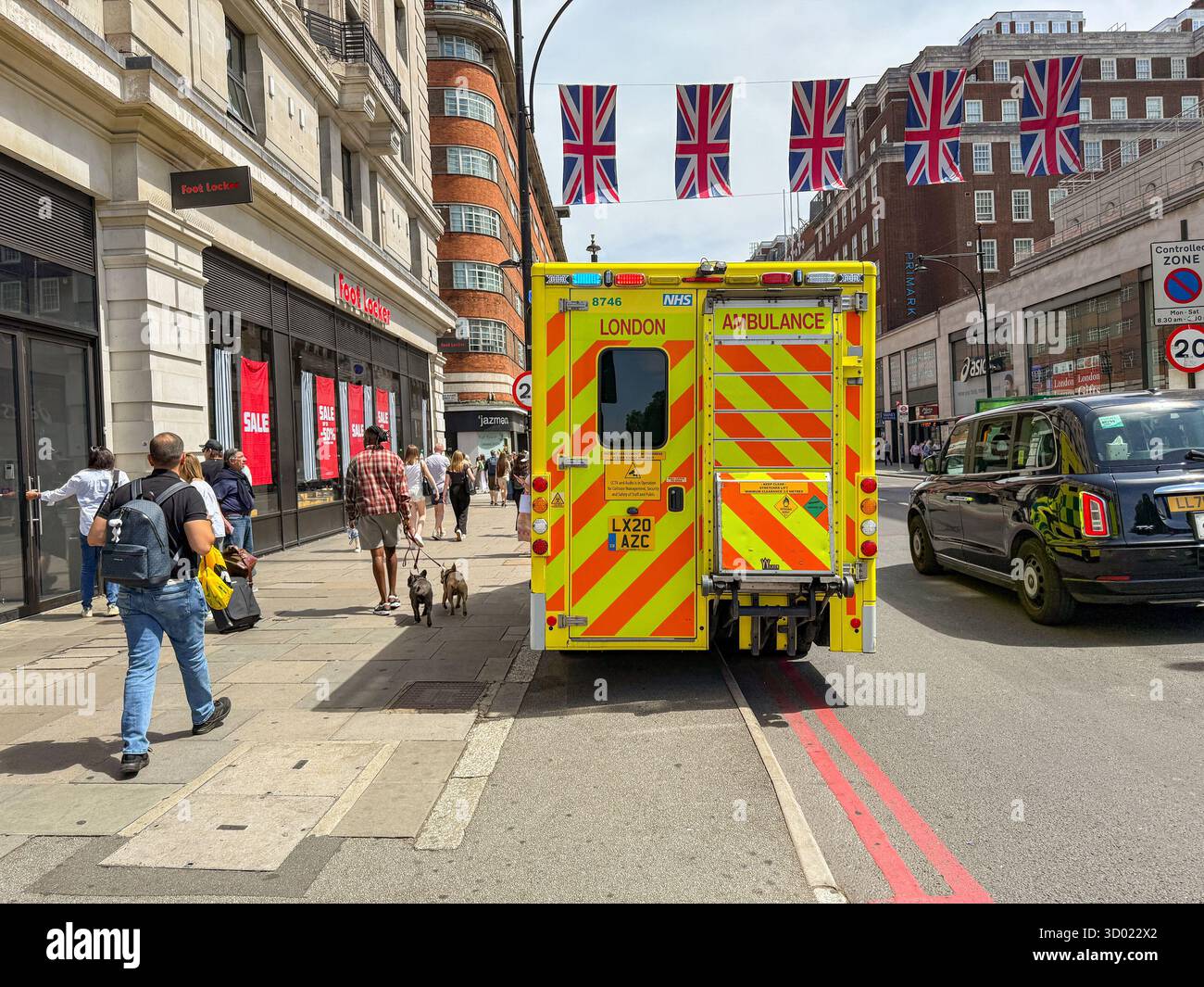 London, England, UK - 4 July 2025: Emergency ambulance of the  London Ambulance Service with flashing lights parked on Oxford Street in central London - Smartphone Captured Stock Image