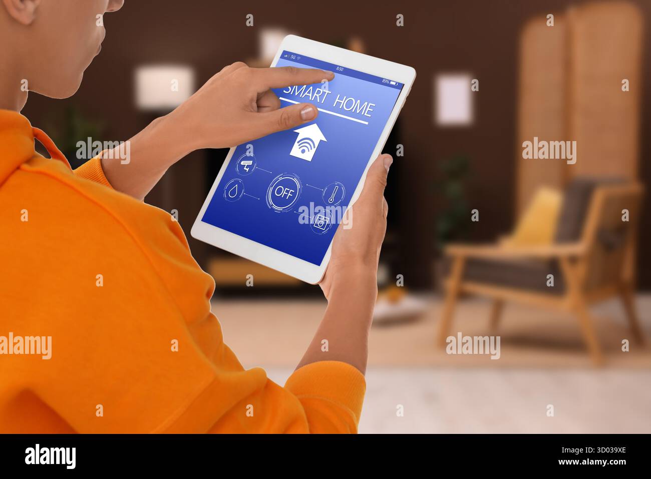 Man using smart home app on tablet computer in room, closeup Stock Photo