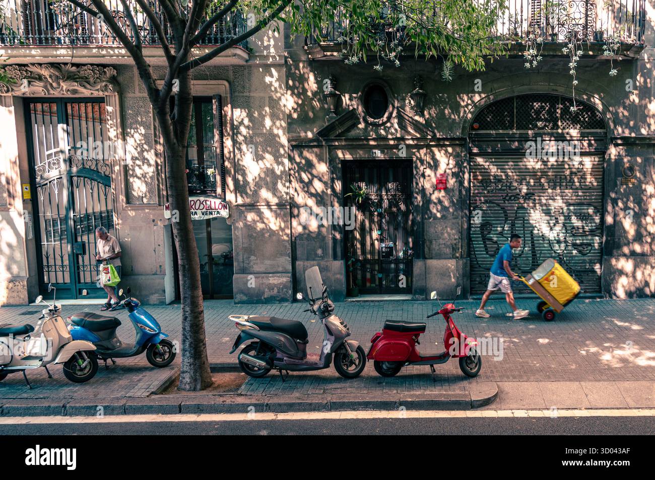 Tarragona streets in sunshine shadows parked scooters on sidewalk Stock Photo