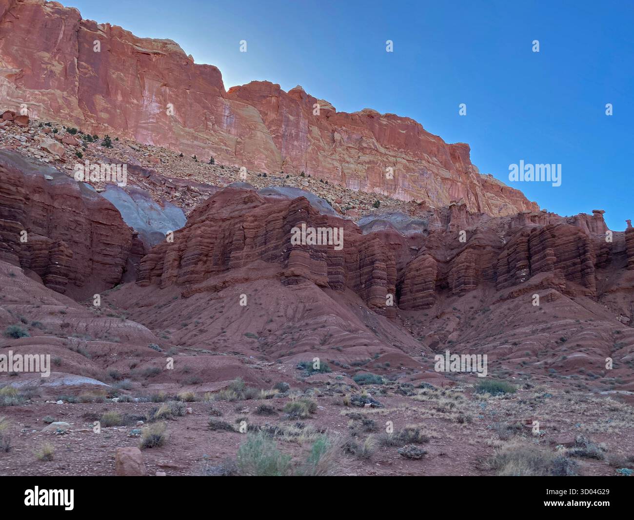 Eroding cliffs of red sandstone and shale, against a clear blue sky, Capitol Reef National Park, Utah, USA - Smartphone Captured Stock Image