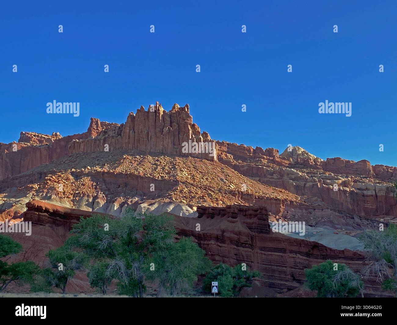 Eroding cliffs of red sandstone and limestone, against a clear blue sky, lining Scenic Byway 24, in Capitol Reef National Park, Utah, USA - Smartphone Captured Stock Image