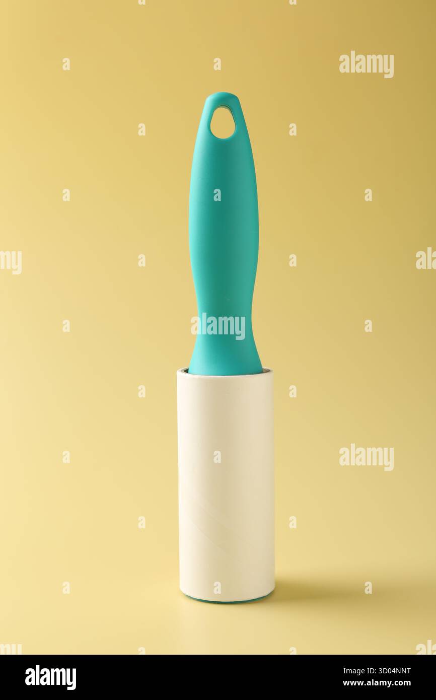 One sticky lint roller on yellow background Stock Photo