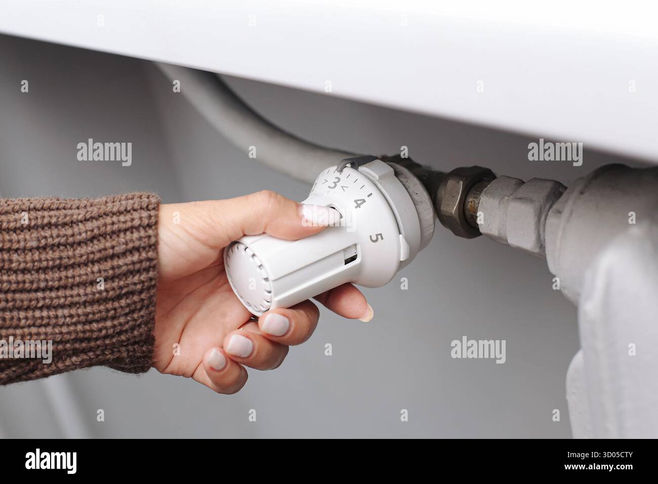 Hand adjusting radiator thermostat valve closeup. Home heating control ...