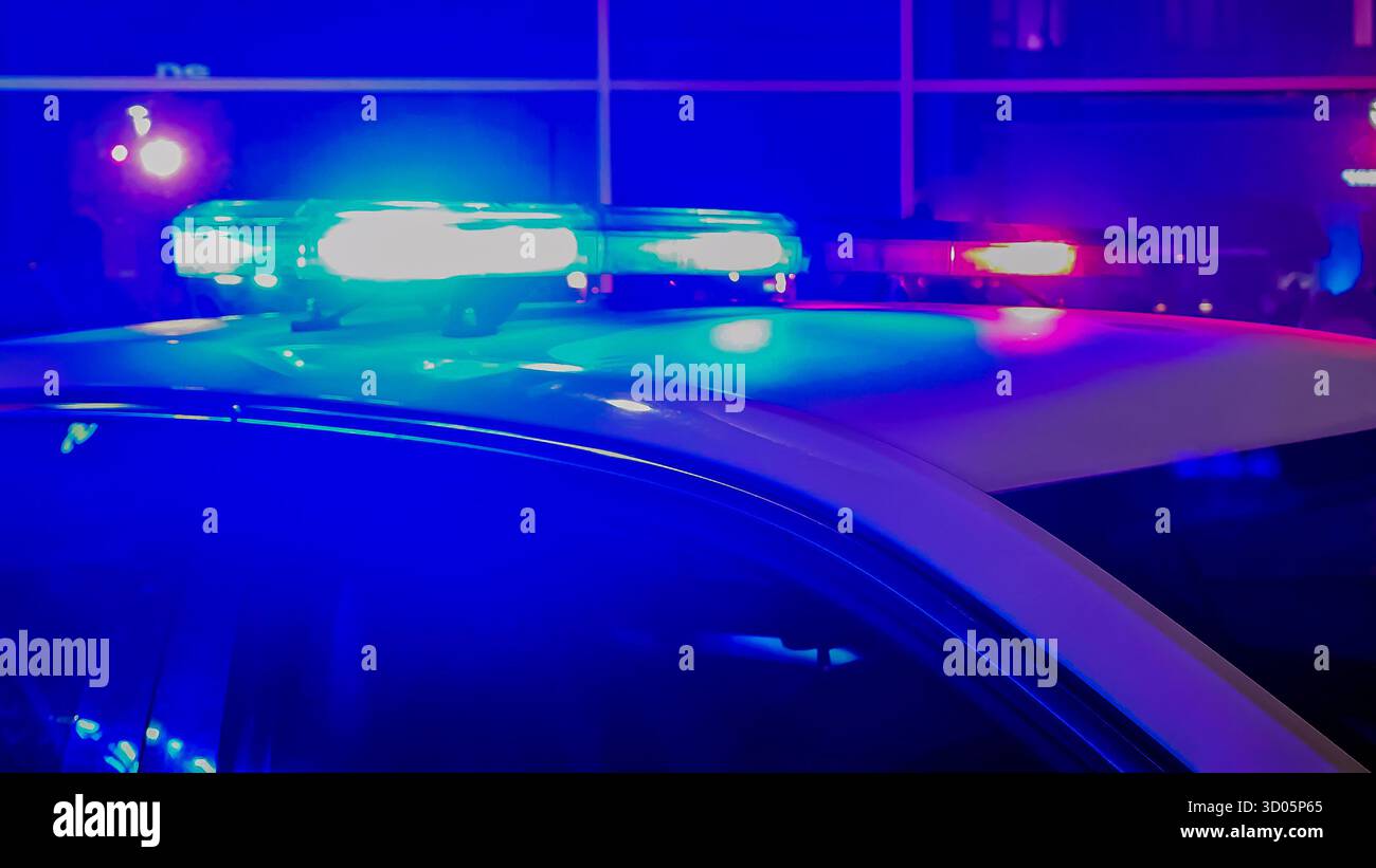 Blue, red light on top of a police vehicle on city street at night - Smartphone Captured Stock Image