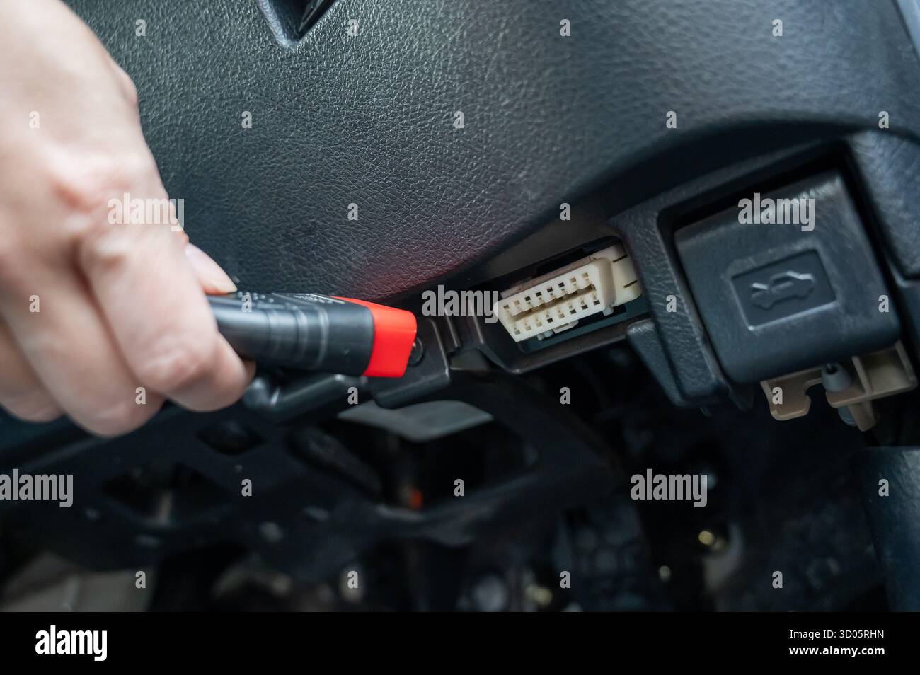 Woman using OBD2 diagnostic scanner. Stock Photo
