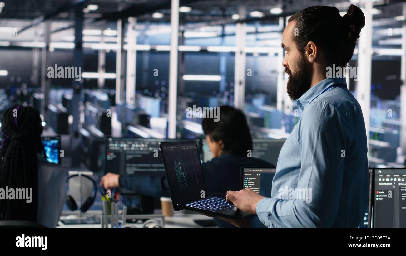 Server room technician using AI LLM chatbot to review infrastructure diagnostics. IT expert in data center using artificial intelligence large language model to analyze performance data, camera A Stock Photo
