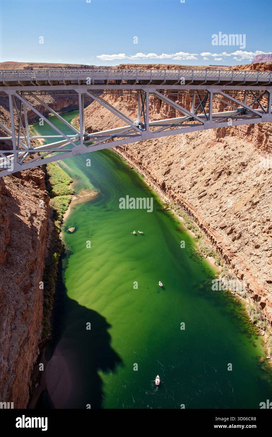 Marble Canyon, Arizona - Dories float under the Navajo Bridge which spans the Colorado River in Marble Canyon, headed towards the Grand Canyon. Stock Photo