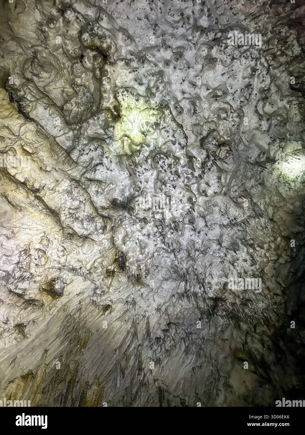 Detailed texture of icy cave wall illuminated by light inside the Ice Cave in Uvac Canyon, showcasing natural rock and mineral formations. - Smartphone Captured Stock Image