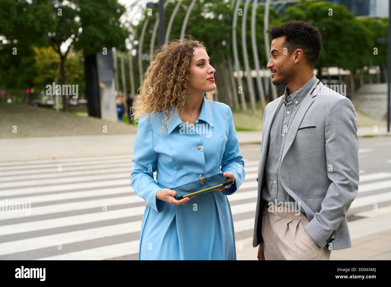 Business colleagues discussing project ideas using tablet outdoors Stock Photo