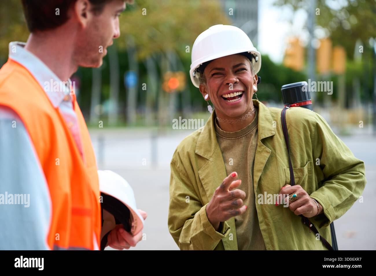 Construction engineers collaborating and laughing outdoors Stock Photo