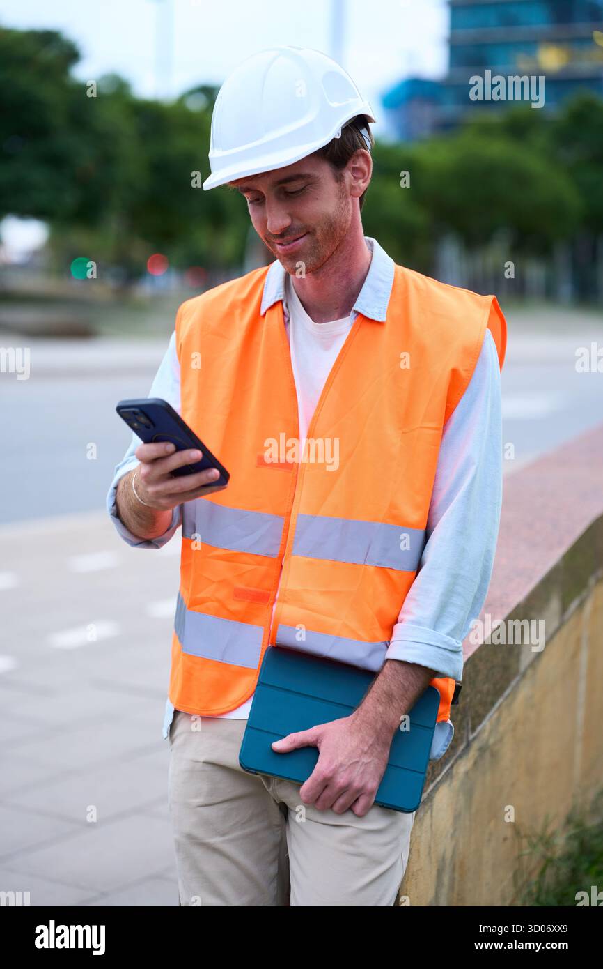 Engineer managing construction site work with digital devices Stock Photo