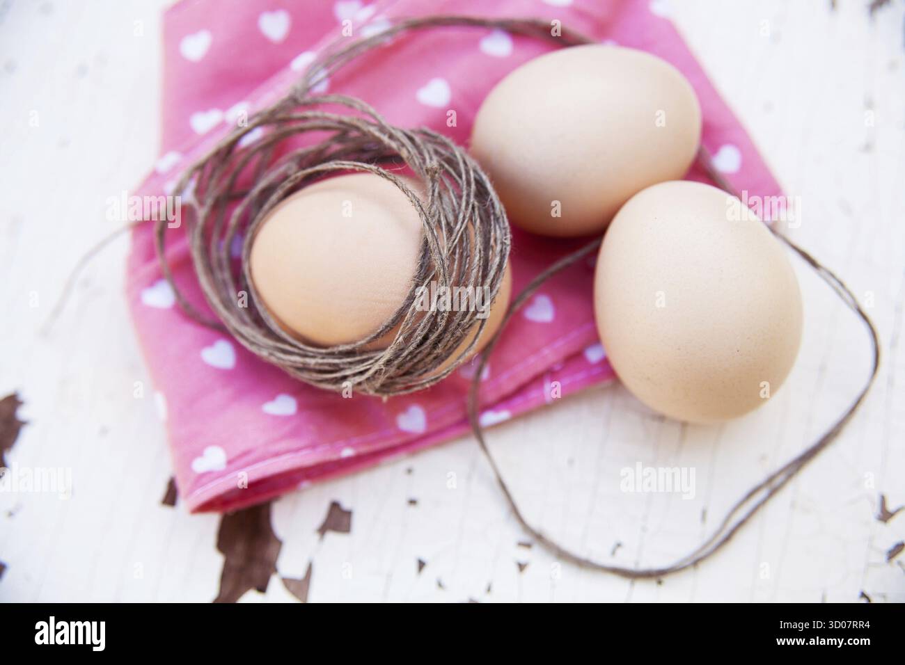 Three eggs on the table on a rose napkin Stock Photo