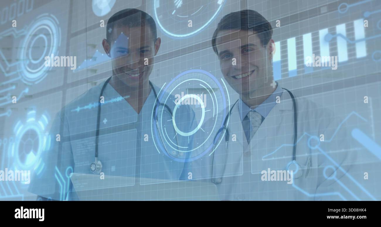 Standing two doctors wearing scrubs, lab coat, stethoscopes viewing digital charts at laptop in lab Stock Photo