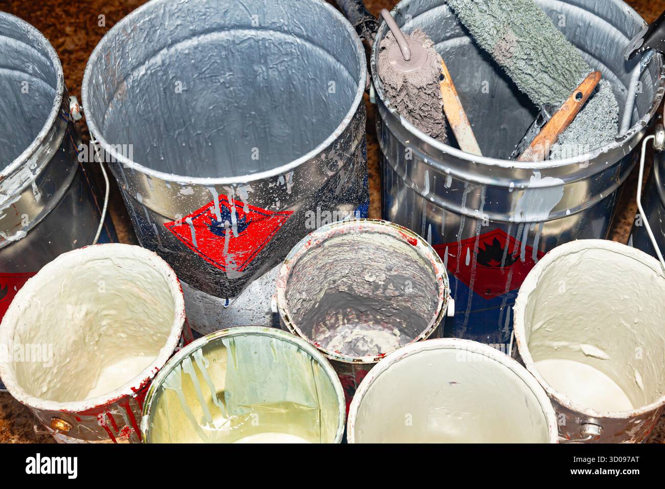 Empty paint buckets containing used rollers and brushes Stock Photo